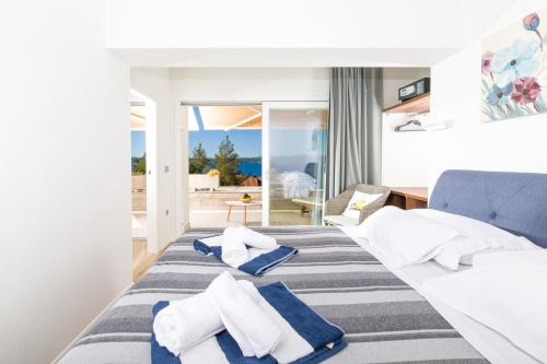 a hotel room with a bed and a view of the ocean at Stella Mare Eco Boutique House in Zavala