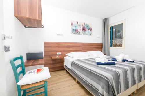 a bedroom with a bed and a blue chair at Stella Mare Eco Boutique House in Zavala