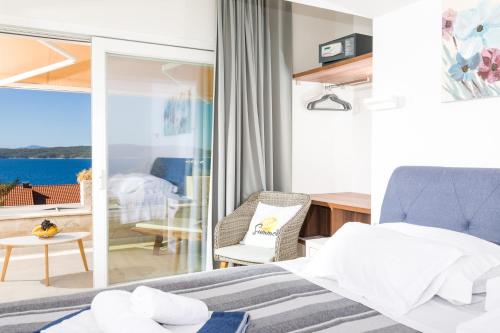 a bedroom with a bed and a view of the ocean at Stella Mare Eco Boutique House in Zavala