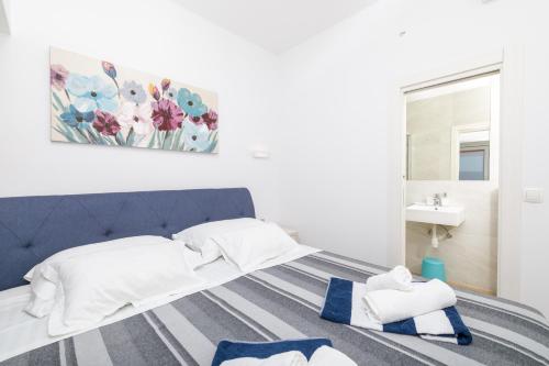 a bedroom with a blue and white bed and a sink at Stella Mare Eco Boutique House in Zavala