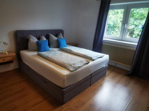 a bedroom with a bed with blue pillows on it at Ferienwohnung Solebad in Gmünd