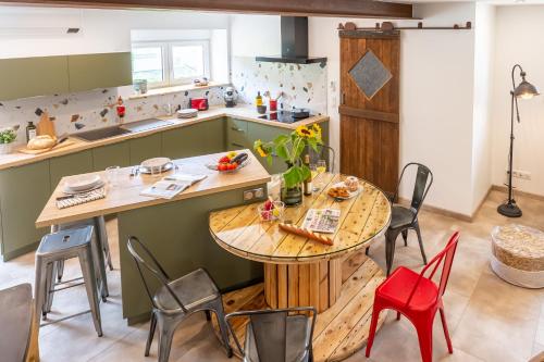 cocina con mesa de madera y sillas rojas en La Pause Verdoyante, en Moosch