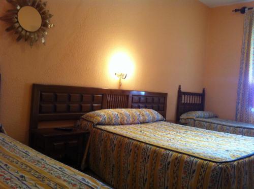 pokój hotelowy z dwoma łóżkami i lustrem w obiekcie Hostal Paracuellos w mieście Paracuellos de Jarama
