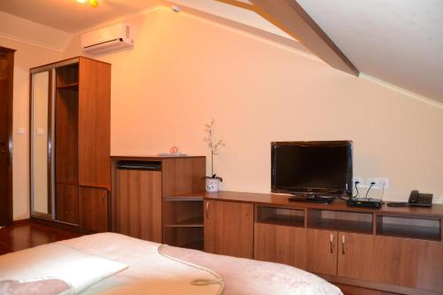 1 dormitorio con 1 cama y TV de pantalla plana en Kruiz Motel, en Kholmok