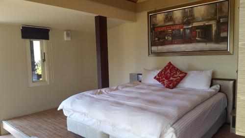 a bedroom with a large white bed with red pillows at Yosemite Park B&B in Renai