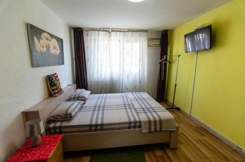 1 dormitorio con 1 cama en una habitación con paredes amarillas en Premium family apartment, Floreasca area, en Bucarest