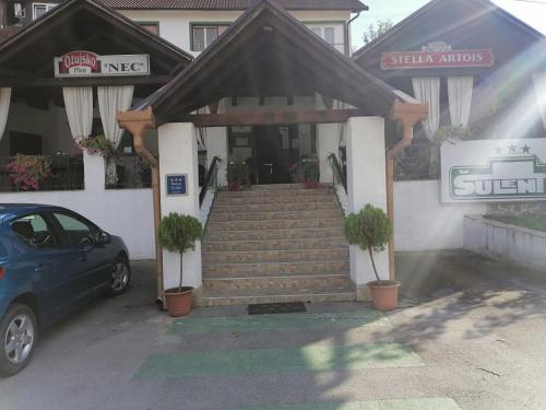 a car parked in front of a building with stairs at Šulentić sobe i restoran in Virovitica