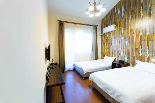 a hotel room with two beds and a window at Gubei Water Town Landscape Villa in Miyun