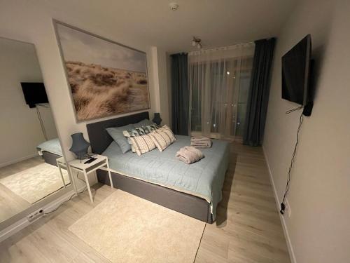 a small bedroom with a bed and a window at 34 floor at the top of the Baltic in Klaipėda