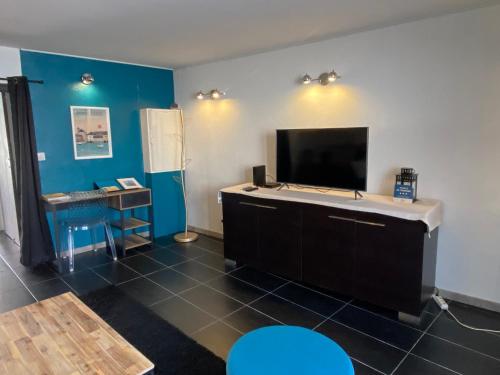 a room with a flat screen tv on a wall at Appartement en entrée de ville avec balneo in Pont-lʼAbbé