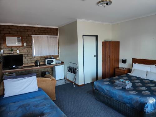 Habitación de hotel con cama y escritorio en Airport Whyalla Motel, en Whyalla