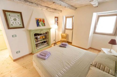 sala de estar amplia con chimenea y cama en La Casetta delle Ragazze Ribelli, en Trarego