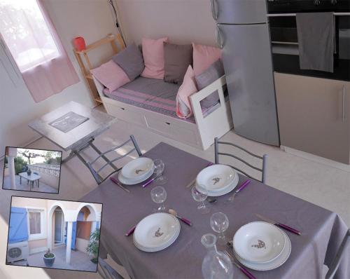 - une table avec des assiettes et des verres à vin au-dessus de la chambre dans l'établissement maison, au Barcarès