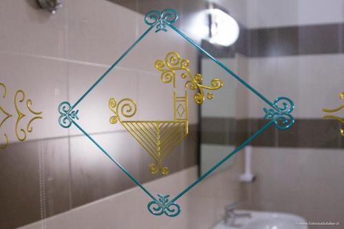 d'un miroir affichant une décoration dorée sur le mur d'une salle de bains. dans l'établissement Agriresort Terradome, à Uta