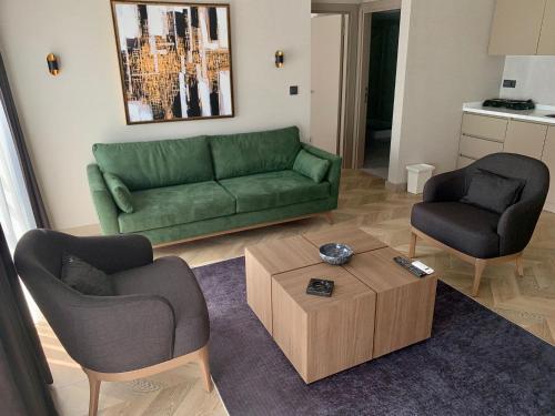 a living room with a green couch and two chairs at Istanbul Park Hotel in Tuzla