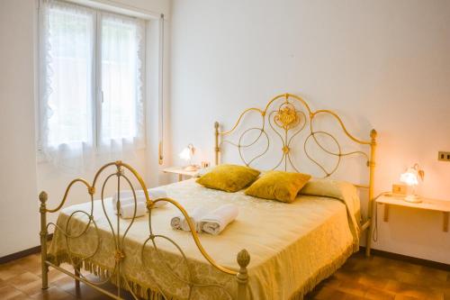a bedroom with a bed with yellow pillows on it at Bellagio Villas in Lezzeno