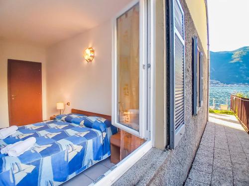 a bedroom with a bed and a balcony with a view at Bellagio Villas in Lezzeno