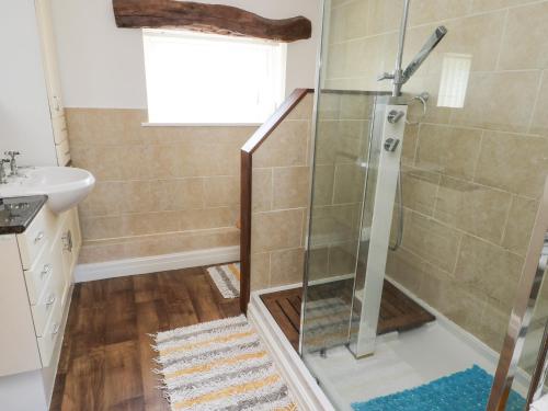 a shower in a bathroom with a glass shower backdoor at Rhosydd Cottage in Llanallgo