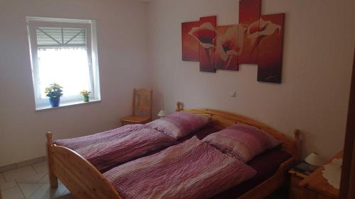a bedroom with a bed with purple sheets and a window at Nordseeholiday in Nordhastedt