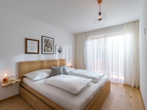 - une chambre avec un grand lit et une fenêtre dans l'établissement Ferienwohnung Wetzinger, à Westendorf