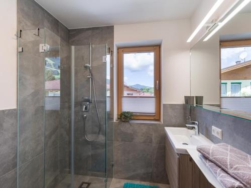 La salle de bains est pourvue d'une douche et d'un lavabo. dans l'établissement Ferienwohnung Wetzinger, à Westendorf