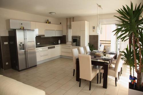 La cuisine est équipée d'une table, de chaises et d'un réfrigérateur. dans l'établissement Apartment Toma, à Kučine