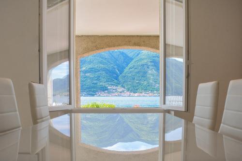 a room with a window with a view of the water at Bellagio Villas in Lezzeno