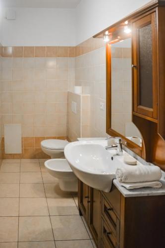 a bathroom with two toilets and a sink and a mirror at Bellagio Villas in Lezzeno