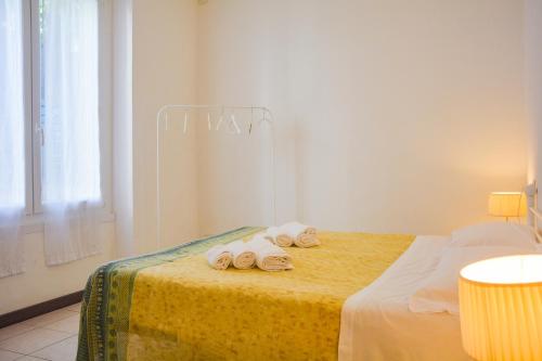 a white room with a bed with towels on it at Bellagio Villas in Lezzeno