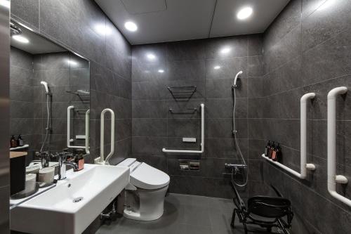 a bathroom with a sink and a toilet and a shower at hotel tou nishinotoin kyoto in Kyoto