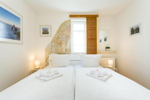 ein Schlafzimmer mit einem weißen Bett und zwei weißen Handtüchern in der Unterkunft Seemöwe - Villa Helene mit Meerblick in Top Lage in Binz