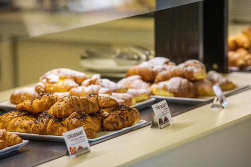 a display case in a bakery with different types of pastries at Hotel Club Saraceno - Bovis Hotels in Àrbatax