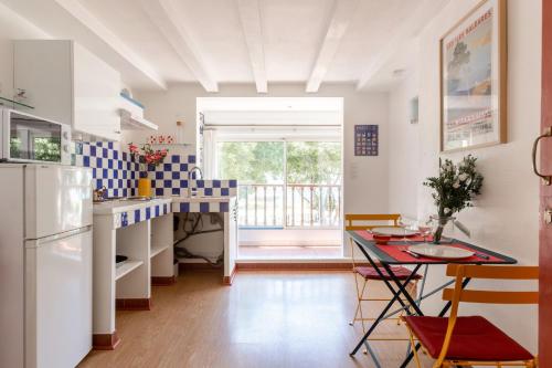 La cuisine est équipée d'un comptoir, d'une table et d'un réfrigérateur. dans l'établissement CABINE 56 - Comme une cabine de Bateau à l'entrée du Port, à Marseille