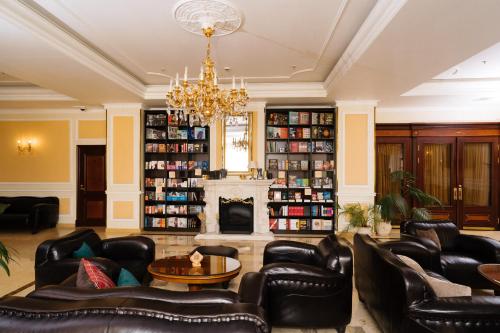 a living room with leather furniture and a fireplace at Grand Hotel Emerald in Saint Petersburg