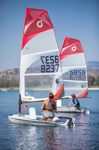 two people on a small sail boat in the water at Hotel Club Saraceno - Bovis Hotels in Àrbatax