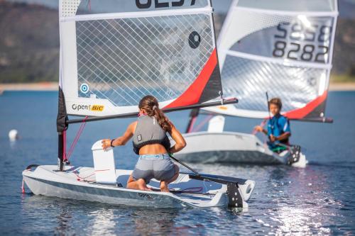 two people on a small sail boat in the water at Hotel Club Saraceno - Bovis Hotels in Àrbatax