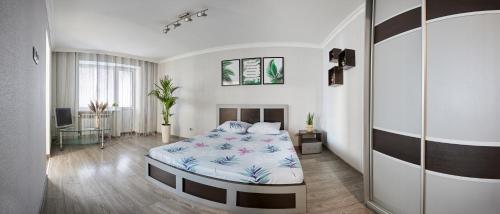 een slaapkamer met een bed met een blauw en wit dekbed bij Babylon Apartments On Chornovola in Rivne