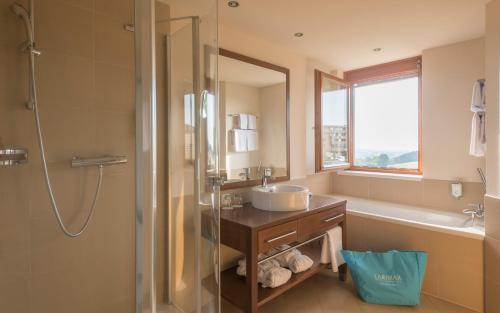 a bathroom with a sink and a shower at Hotel & Spa Larimar in Stegersbach