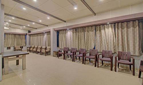 a conference room with chairs and tables and curtains at Treebo Sumati Baner in Pune