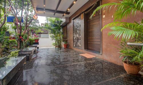 a rain soaked hallway with plants and a door at Treebo Sumati Baner in Pune
