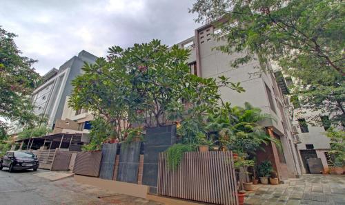 a building with a fence and trees in front of it at Treebo Trend Sumati Baner in Méribel Village