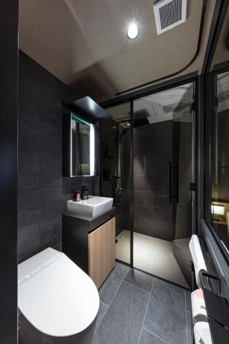 a bathroom with a toilet and a sink and a shower at hotel tou nishinotoin kyoto in Kyoto