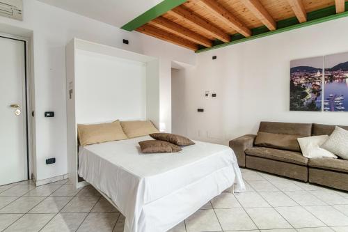 ein weißes Schlafzimmer mit einem Bett und einem Sofa in der Unterkunft Appartamento Centro Storico in Como