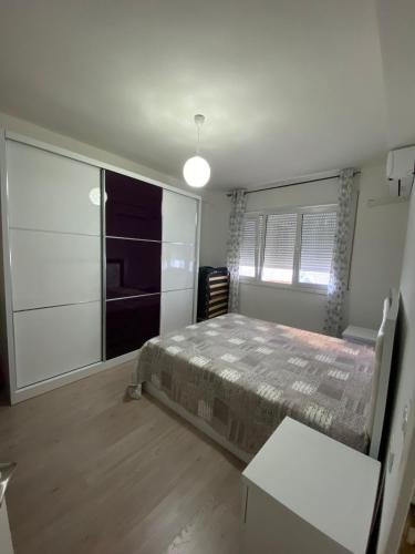 a bedroom with a bed and a large window at Appartamento Saranda in Sarandë