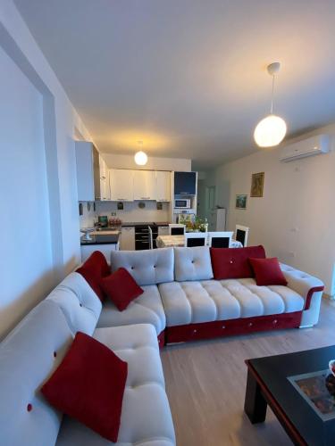 a living room with a white couch and red pillows at Appartamento Saranda in Sarandë