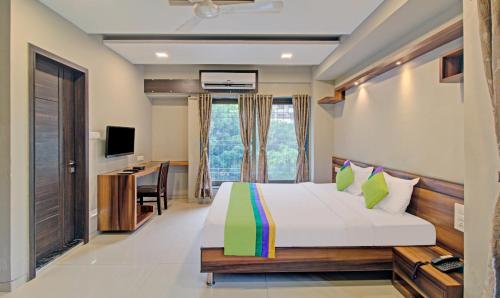 a bedroom with a bed and a desk and a television at Treebo Sumati Baner in Pune