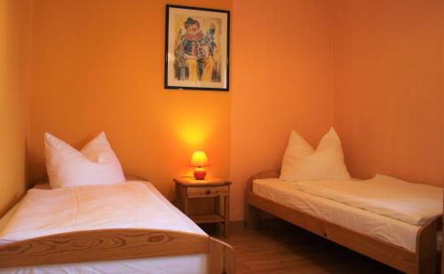 Ce lit se trouve dans un dortoir doté de murs orange et d'une lampe. dans l'établissement Seute Deern, à Kirchdorf