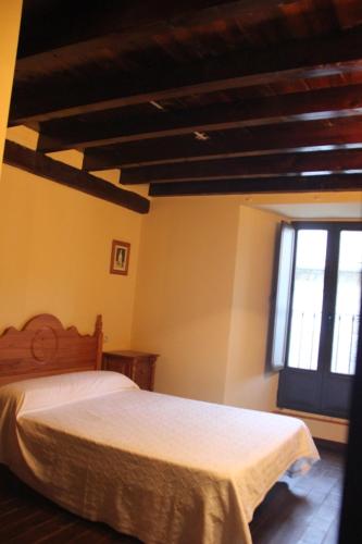 a bedroom with a bed and a window at Casa Rural la Cancha I in Navalacruz