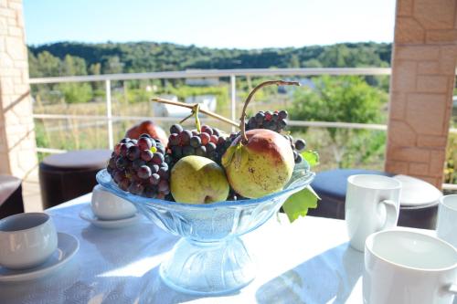 a glass bowl of fruit sitting on a table at Villa Vicky Corfu in Agios Ioannis