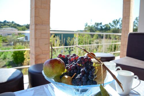 a bowl of fruit on a table on a balcony at Villa Vicky Corfu in Agios Ioannis